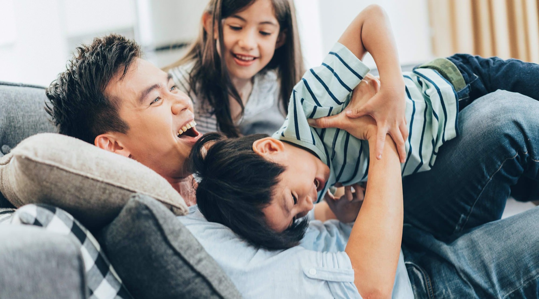 a family laughing together on a couch